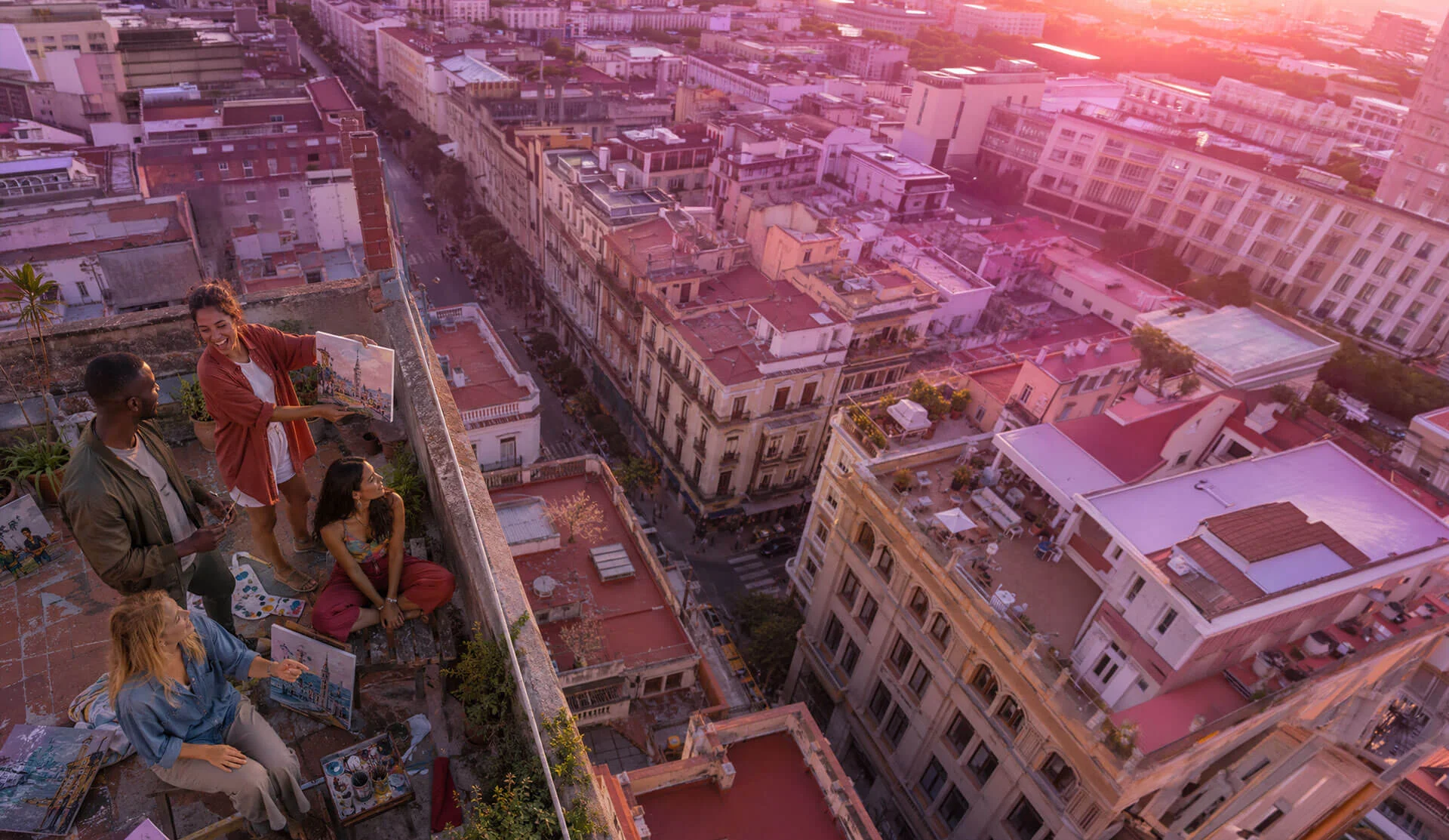 Friends painting together on a rooftop at golden hour